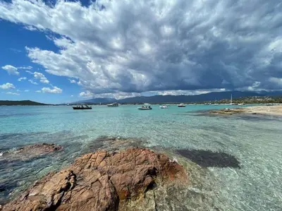 a group of boats in the water on a beach at Villa La Rondina vue mer, piscine et plage à pied. in Zonza