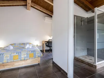 a bedroom with a bed and a glass shower at Holiday Home Mela by Interhome in Sotta