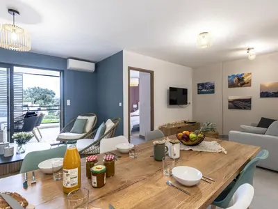 a dining room and living room with a wooden table at Apartment Vignola 2 by Interhome in Porto-Vecchio