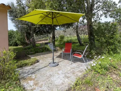 a yellow umbrella and two chairs on a patio at Holiday Home A Vigna by Interhome in Sotta