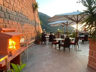 a patio with tables and chairs and an umbrella at Appartement T2 Porto in Porto Ota