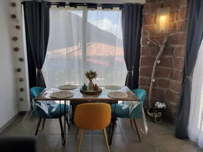 a dining room table and chairs in front of a window at Appartement T2 Porto in Porto Ota