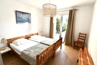 a bedroom with two beds and a window at Appartement 60m2 avec piscine privée dans villa in Oletta