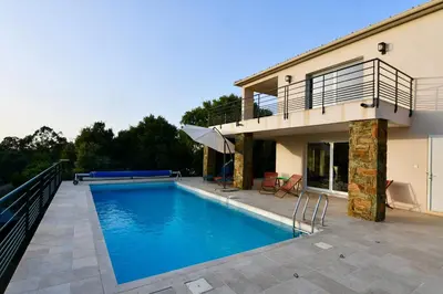 a swimming pool in front of a house at Appartement 60m2 avec piscine privée dans villa in Oletta