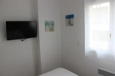 a white room with a flat screen tv on a wall at T3 vue mer direct plage clim N79 in Linguizzetta