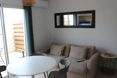 a living room with a couch and a table and a mirror at T3 vue mer direct plage clim N79 in Linguizzetta
