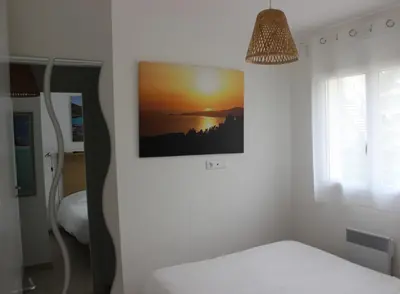 a bedroom with a bed and a picture on the wall at T3 vue mer direct plage clim N79 in Linguizzetta