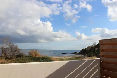 a view of the ocean from a white fence at T3 vue mer direct plage clim N79 in Linguizzetta
