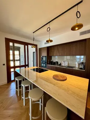 a kitchen with a large wooden counter with stools at Hyper Centre, Front De Mer in Ajaccio