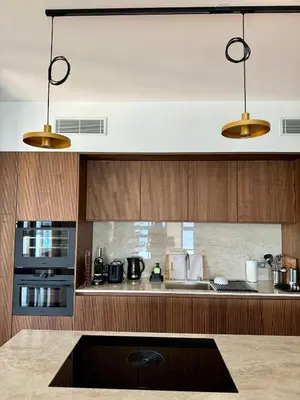 a kitchen with wooden cabinets and two lights at Hyper Centre, Front De Mer in Ajaccio