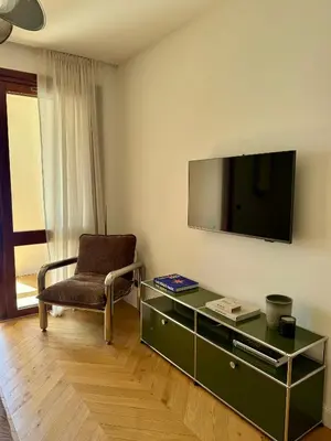 a living room with a chair and a tv on a wall at Hyper Centre, Front De Mer in Ajaccio
