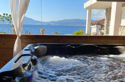 a hot tub in a house with a view of the ocean at Résidence CasaBianca Porticcio - Aïtone in Porticcio