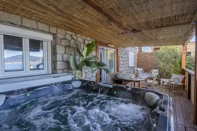 a jacuzzi tub in a room with a table at Résidence CasaBianca Porticcio - Aïtone in Porticcio