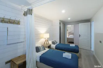 a bedroom with two beds with blue sheets at Résidence CasaBianca Porticcio - Aïtone in Porticcio
