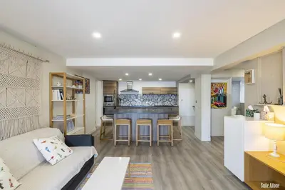 a living room with a couch and a kitchen at Résidence CasaBianca Porticcio - Aïtone in Porticcio