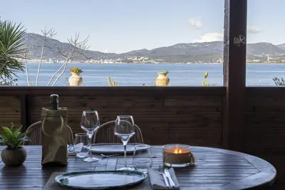 a table with wine glasses and a view of the ocean at Résidence CasaBianca Porticcio - Aïtone in Porticcio