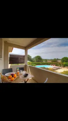 a table with oranges on it with a view of a pool at Appartement proche des plages in Porto-Vecchio