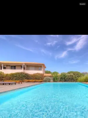 a large swimming pool in front of a house at Appartement proche des plages in Porto-Vecchio