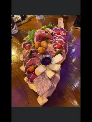 a plate of food with meats and cheese on a table at Appartement proche des plages in Porto-Vecchio