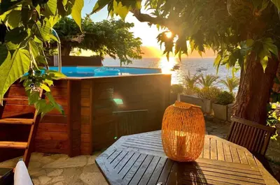 an outdoor hot tub with a vase sitting on a table at Résidence CasaBianca Porticcio - San Petru in Porticcio