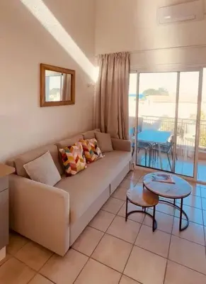 a living room with a couch and a table at Charmant T2 rénové avec vue mer in Cervione