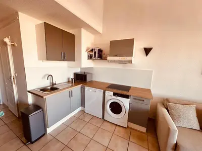 a kitchen with a washer and dryer in a room at Charmant T2 rénové avec vue mer in Cervione