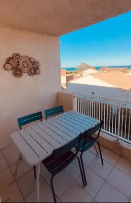 a blue table and chairs on a balcony with a table at Charmant T2 rénové avec vue mer in Cervione