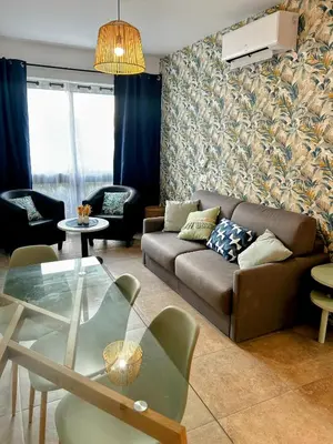 a living room with a couch and a glass table at Entre montagne et mer in Porto Ota