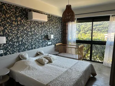 a bedroom with a white bed with two pillows at Entre montagne et mer in Porto Ota
