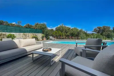 a patio with a couch and chairs and a pool at Villa Arinella Villata Di Capicciola in Sainte-Lucie de Porto-Vecchio