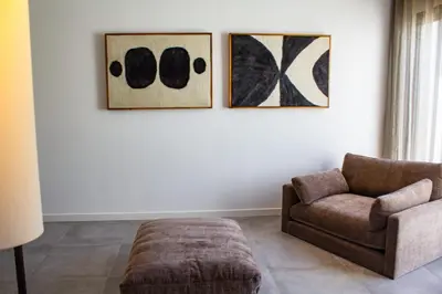 a living room with a couch and two paintings on the wall at Villa Arinella Villata Di Capicciola in Sainte-Lucie de Porto-Vecchio