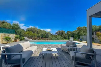 a patio with a couch and chairs and a pool at Villa Arinella Villata Di Capicciola in Sainte-Lucie de Porto-Vecchio