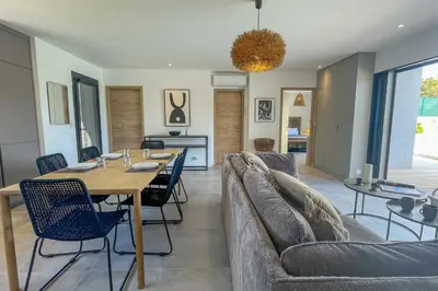 a dining room and living room with a table and chairs at Villa Arinella Villata Di Capicciola in Sainte-Lucie de Porto-Vecchio