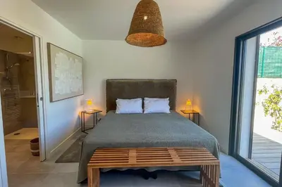 a bedroom with a bed with two lamps and a table at Villa Arinella Villata Di Capicciola in Sainte-Lucie de Porto-Vecchio