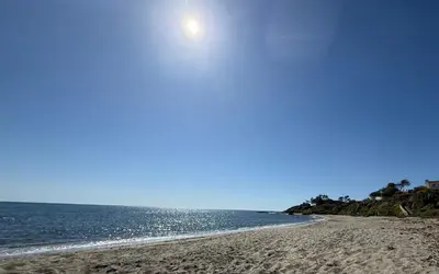 an empty beach with the sun in the sky at Appartement 2 pièces bord de mer in Linguizzetta