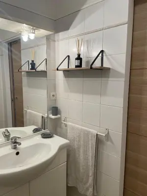 a white bathroom with a sink and a mirror at Appartement 2 pièces bord de mer in Linguizzetta