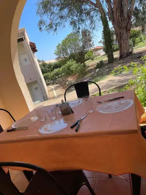 a table with glasses and plates on it with a window at Appartement 2 pièces bord de mer in Linguizzetta