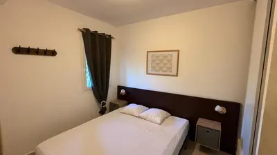 a bedroom with a bed with white sheets and a window at Appartement 2 pièces bord de mer in Linguizzetta