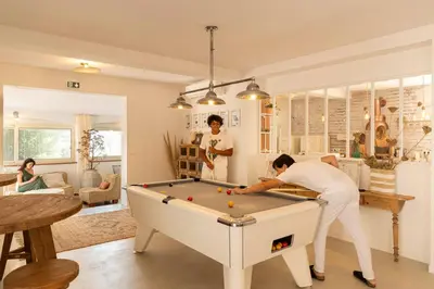 a woman playing a game of pool in a living room at Corsica Hostel Porto-Vecchio, partie dortoirs in Porto-Vecchio