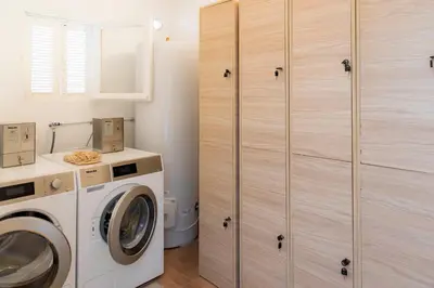 a laundry room with a washing machine and cabinets at Corsica Hostel Porto-Vecchio, partie dortoirs in Porto-Vecchio