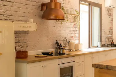 a kitchen with white cabinets and a large window at Corsica Hostel Porto-Vecchio, partie dortoirs in Porto-Vecchio