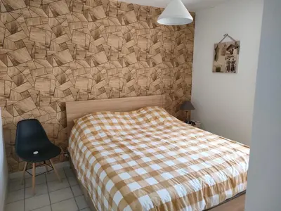 a bedroom with a bed and a stone wall at Sartène Appartement 3 pièces vue mer avec jardin in Sartène