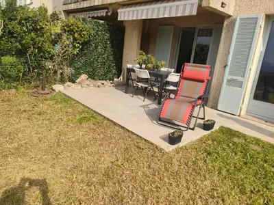 a patio with two chairs and a table in a yard at Sartène Appartement 3 pièces vue mer avec jardin in Sartène