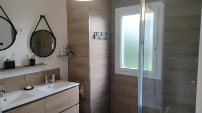 a bathroom with a sink and a glass shower at Sartène Appartement 3 pièces vue mer avec jardin in Sartène
