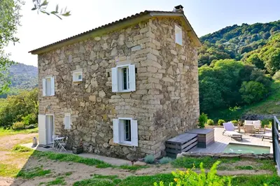 a stone house with a pool in front of it at Particasgiu - Agritourisme in Vico