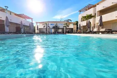 a swimming pool with blue water in a hotel at Studio 2 personnes vue mer et pieds dans l'eau in Linguizzetta