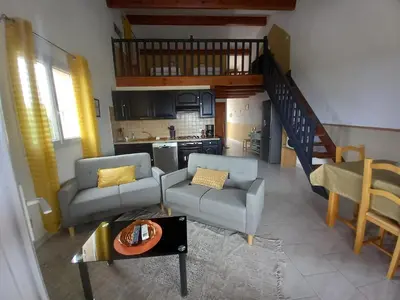 a living room with a couch and chairs and a kitchen at A CASA DI PAULINA in Serra-di-Ferro