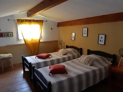 a bedroom with two beds and a light on the wall at A CASA DI PAULINA in Serra-di-Ferro