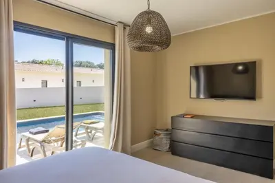 a bedroom with a bed and a television and a patio at Villa Vignarella in Sorbo-Ocagnano