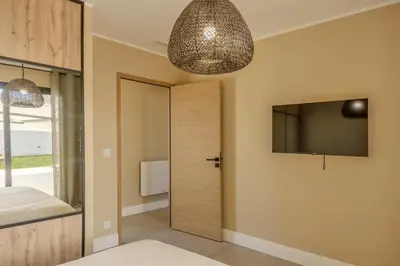 a bedroom with a door with a television and a chandelier at Villa Vignarella in Sorbo-Ocagnano